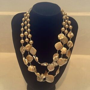 Metallic three strand necklace with lobster claw clasp.